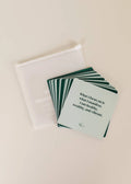 JaxKelly Shower Affirmation™ Cards - Abundance are waterproof cards fanned out next to a translucent white pouch. The visible card reads: What I focus on is what I manifest. Perfect daily abundance quotes for inspiration.
