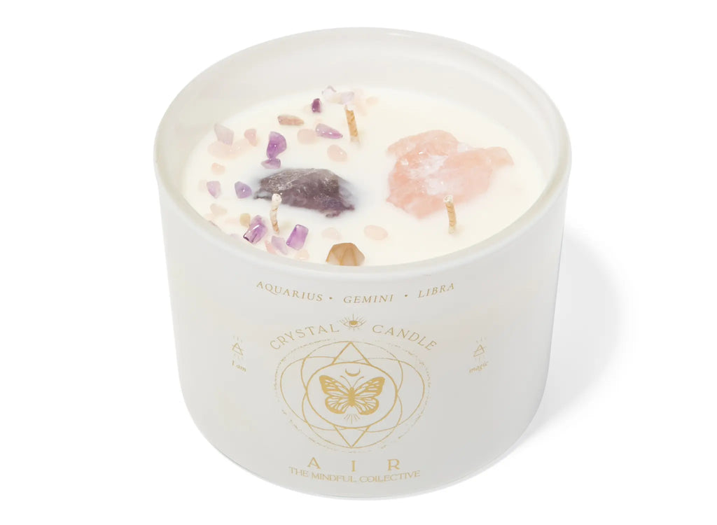 The Air Elements Candle 12oz by THE MINDFUL COLLECTIVE comes in a frosted glass jar labeled AIR with Aquarius, Gemini, and Libra symbols. Topped with crystals and gemstones, it’s perfect for celebrating air signs.