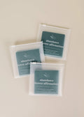 Three teal Shower Affirmation™ Cards - Abundance by JaxKelly, each with abundance quotes, are displayed in clear pouches on a beige surface. These waterproof, reusable cards are ideal for your daily self-care routine.