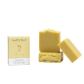 Three bars of yellow soap with a box labeled 'Luna & Co. Soapery' on a white background