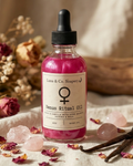 Bottle of Luna & Co. Soapery Venus Ritual Oil with flowers and crystals on a soft background