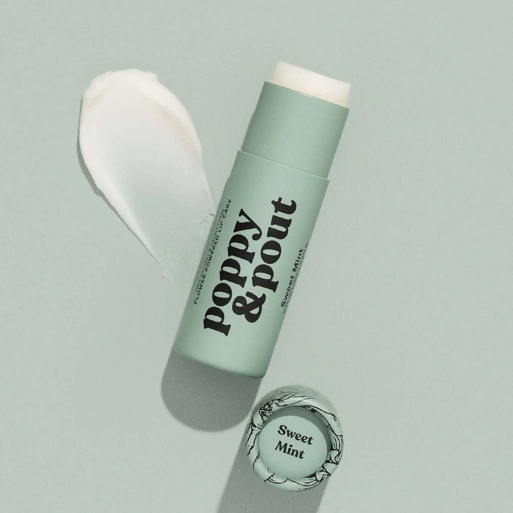 A light green tube of Poppy & Pout Lip Balm in Sweet Mint is open with its cap beside it, and a swatch of the cruelty-free balm appears on a matching green background.