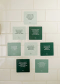 JaxKelly’s Shower Affirmation™ Cards – Abundance set features nine green waterproof cards arranged on white tile, each printed with positive, wealth-focused quotes to inspire abundance and positivity during your shower routine.