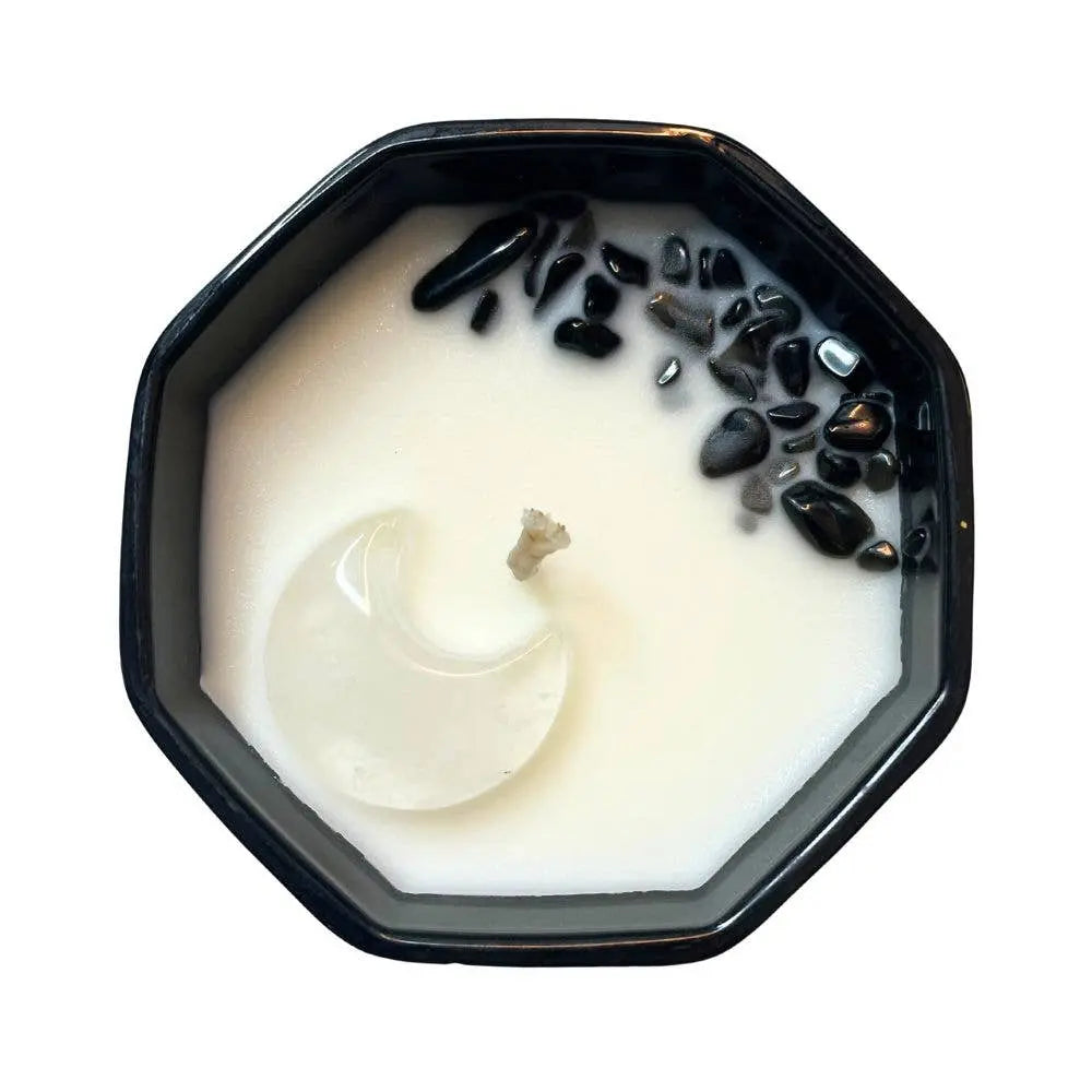 A pack of 6 Earths Elements Wholesale Crystal Candles, Moon Phase edition, features black octagonal jars with white wax, crescent moon shapes, and Black Obsidian stones on one side, shown from above on a white background.